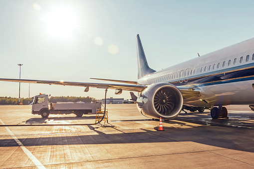 a supply management truck refuels an airplane on an airport field