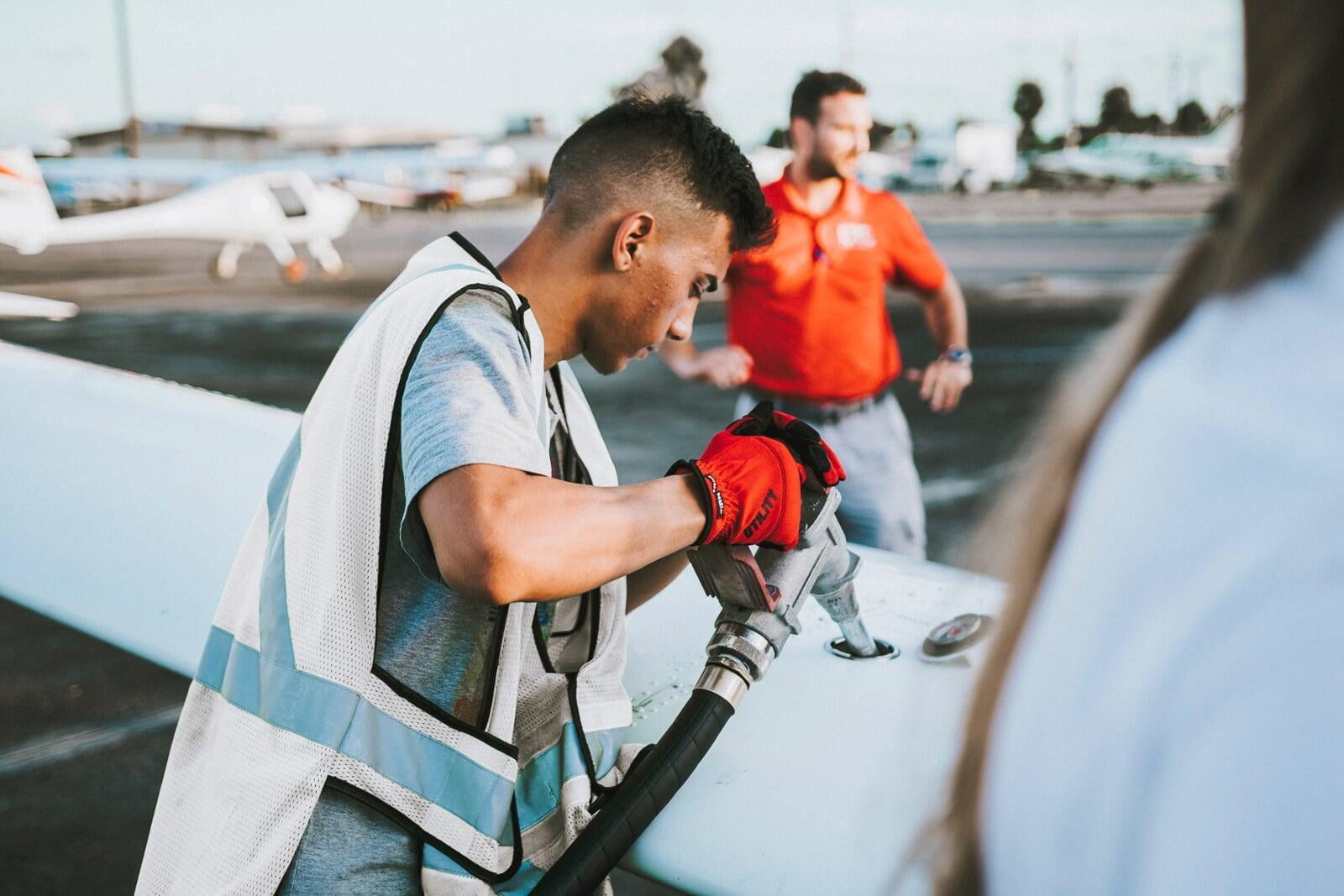 Aircraft specialist refuels the wing of an airplane